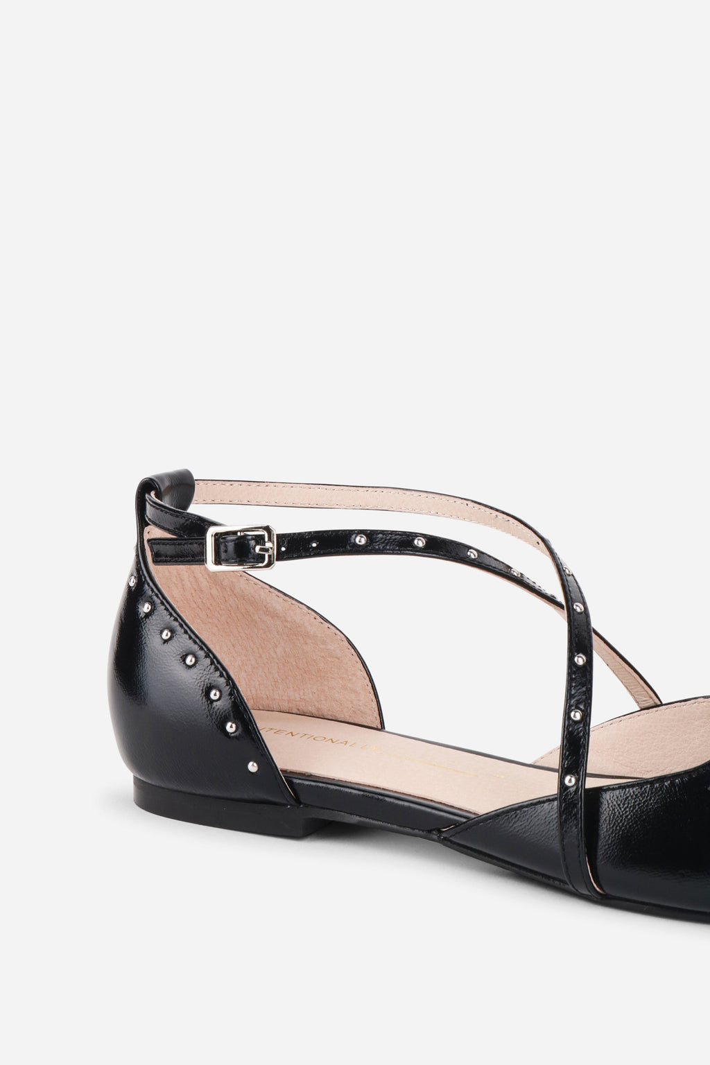 "INTENTIONALLY __________." Crowd Studded Criss Cross Flat