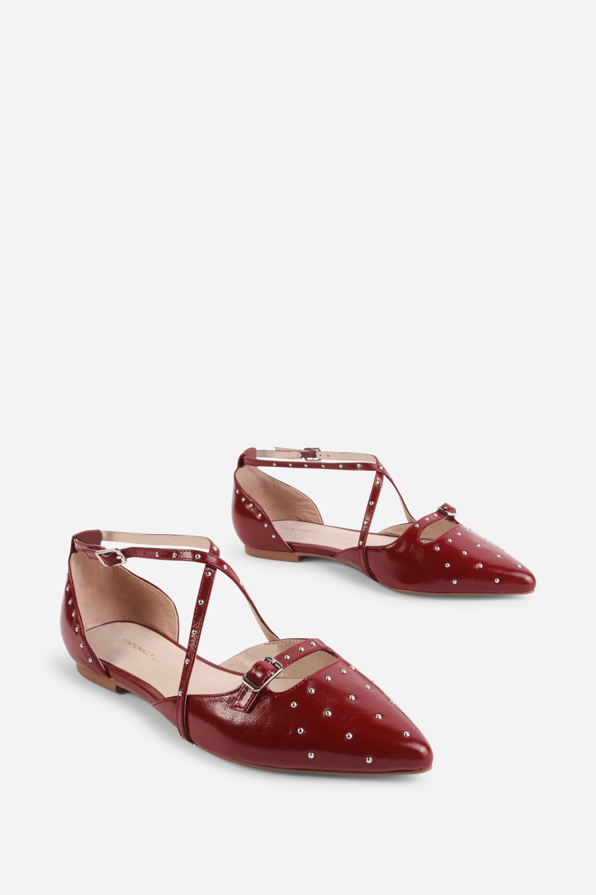 "INTENTIONALLY __________." Crowd Studded Criss Cross Flat